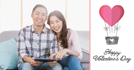 Composite of couple using digital tablet at homeの写真素材