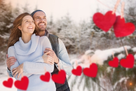 Happy couple with hearts against snow backgroundの写真素材