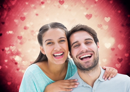 Portrait of smiling couple against digitally generated backgroundの写真素材