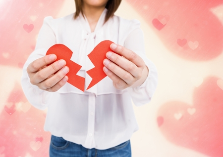 Mid-section of woman holding a broken heart against digitally generated backgroundの写真素材