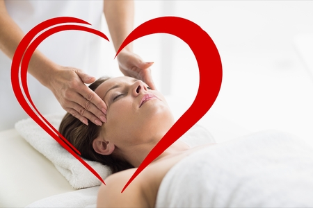 Woman receiving spa with digitally generated heartの写真素材