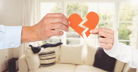 Hand of couple holding broken hearts at home