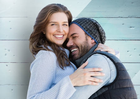 Happy couple embracing each other against wooden backgroundの写真素材