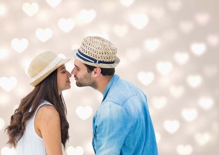 Romantic couple kissing each other against digitally generated heart backgroundの写真素材