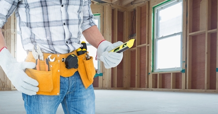 Mid section of handyman holding worktool in workshopの写真素材