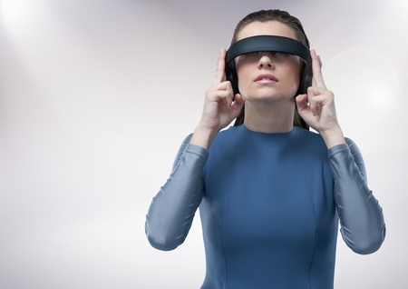 Attractive woman using virtual reality headset against white backgroundの写真素材