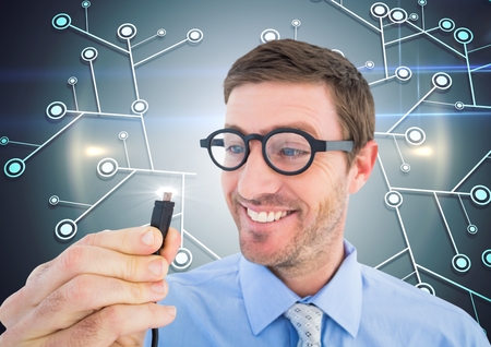 Nerd man holding cable with flare against digitally generated backgroundの写真素材