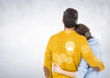 Rear view of couple embracing each other against digitally generated white backgroundの写真素材