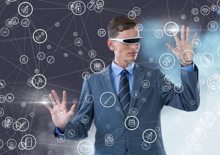 Businessman with using virtual reality headset holding connecting icons against digital generated...