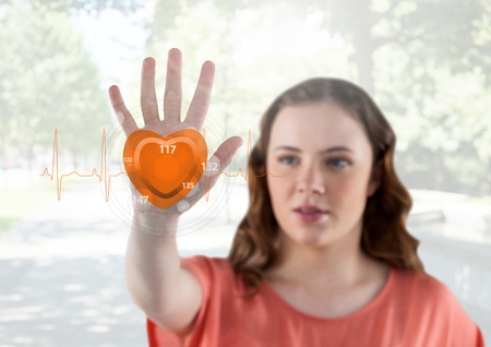 Beautiful woman touching digitally generated pulse rateの写真素材