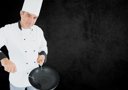 Portrait of chef pretending to cook against black backgroundの写真素材
