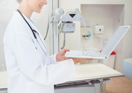 Mid section of doctor using laptop in hospitalの写真素材