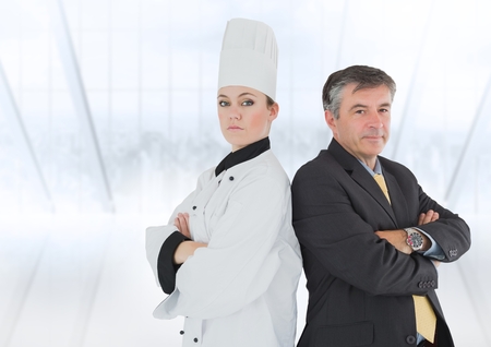 Portrait of female chef and businessman with arms crossed against blue backgroundの写真素材