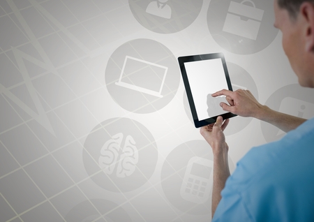 Doctor using digital tablet against digitally generated icons and grey interfaceの写真素材