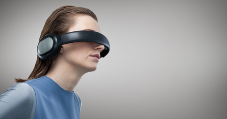 Woman using virtual reality headset against grey backgroundの写真素材