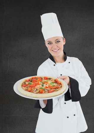 Composite image of smiling female chef with pizza against black backgroundの写真素材