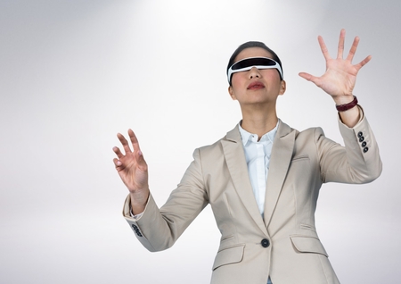 Businesswoman using virtual reality headset against grey background