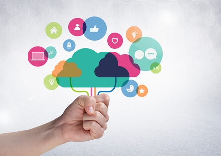 Close-up of hand holding digital composite clouds with digital icon against white backgroundの写真素材