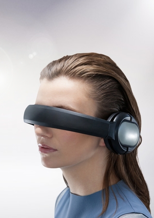 Woman using virtual reality headset against grey backgroundの写真素材