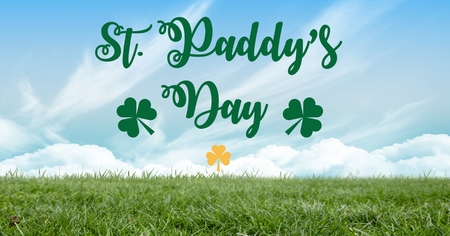 Digital composite of Patrick's Day graphic with yellow shamrock against sky and grassの写真素材