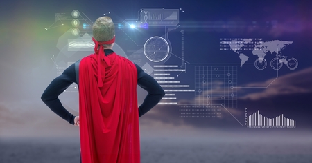 Digital composite of Man dressed up as superhero standing in front of futuristic interfaceの写真素材