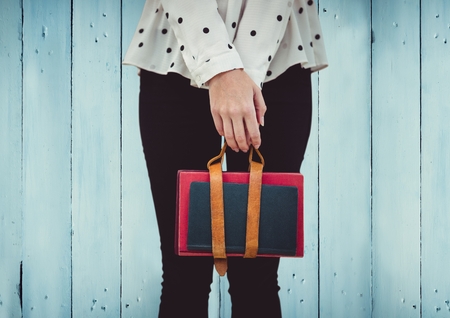 Digital composite of Woman's legs with handbag against blue wood panelの写真素材