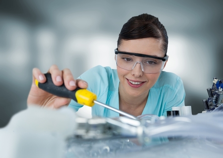 Digital composite of Woman with electronics in blurry grey room