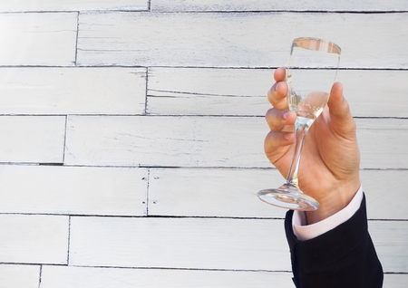Digital composite of Wedding groom hand holding champagne celebrating against woodの写真素材