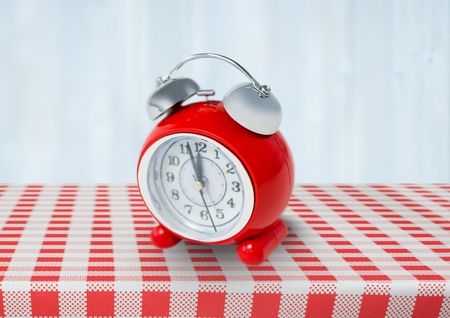 Digital composite of Clock on red tablecloth