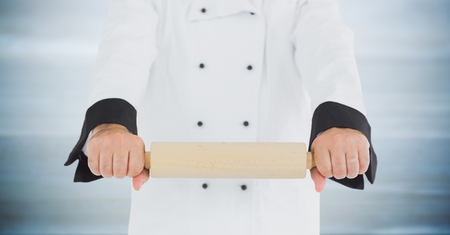 Digital composite of Chef with rolling pin against blurry grey wood panelの写真素材
