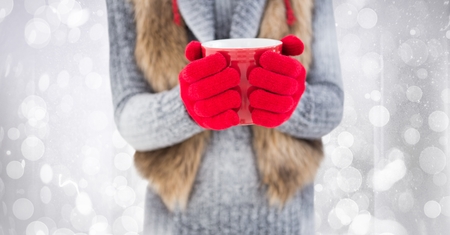 Digital composite of Woman mid section with red coffee cup against white bokehの写真素材