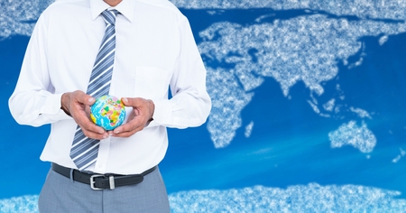 Digital composite of Travel agent mid section holding globe against map with clouds and blue backgroundの写真素材