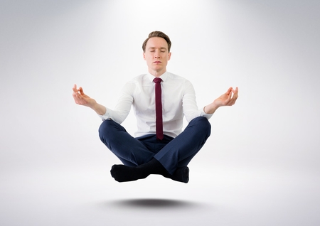 Digital composite of Businessman Meditating  floating against grey backgroundの写真素材