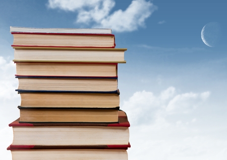 Digital composite of Books stacked by blue skyの写真素材