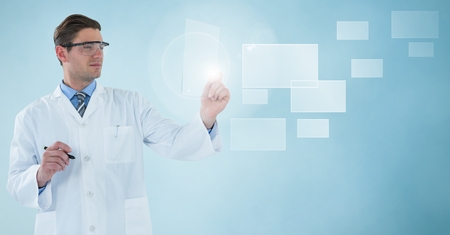 Digital composite of Man in lab coat and goggles with pen holding up glass device at square interface against blue backgrの写真素材