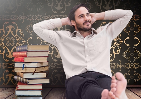 Digital composite of Man sitting relaxed with Books stacked by antique wallpaper decorativeの写真素材