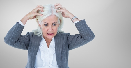 Digital composite of Stressed older woman against grey backgroundの写真素材