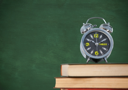 Digital composite of Pile of books with clock against green chalkboardの写真素材
