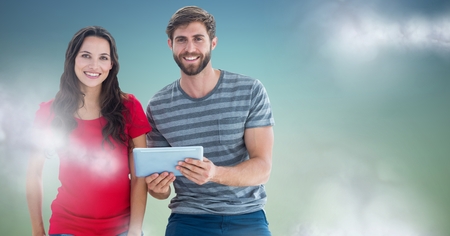 Digital composite of Couple with tablet against blue green background with clouds