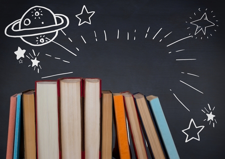 Digital composite of Standing books with white space doodles against navy chalkboardの写真素材