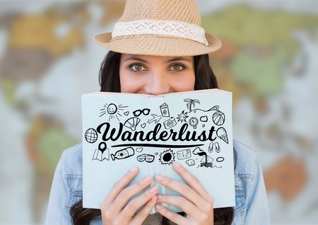 Digital composite of Woman reading with black wanderlust doodles against blurry mapの写真素材