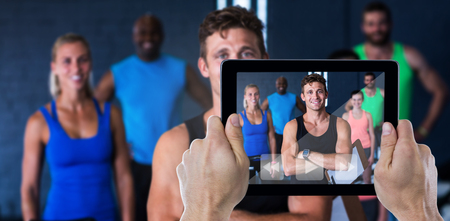 Composite image of cropped hand holding digital tabletの写真素材