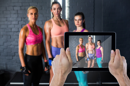 Composite image of cropped hand holding digital tabletの写真素材