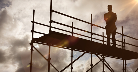 Portrait of happy repairman standing arms crossed against blue sky with white clouds