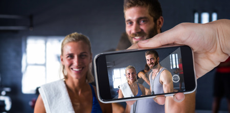 Composite image of hand holding mobile phone against white backgroundの写真素材