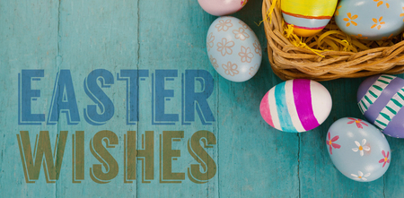 Easter greeting against various easter eggs arranged in wicker basketの写真素材