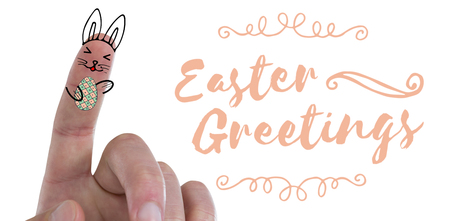 Digitally composite image of fingers representing Easter bunny  against easter greetingの写真素材