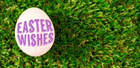 Easter greeting against white easter egg on grass
