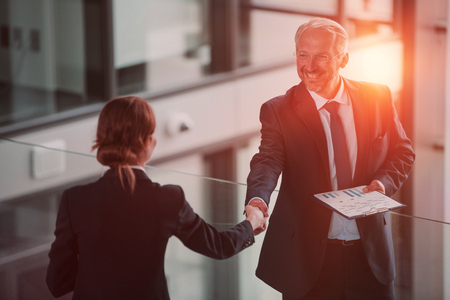 Businessman shaking hands with colleague in officeの写真素材
