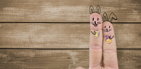 Fingers representing Easter bunny  against woodの写真素材